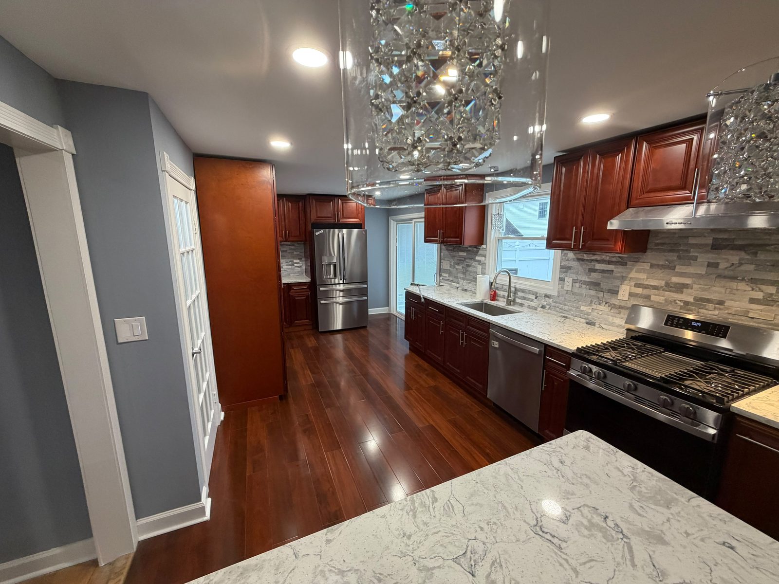 Renovated kitchen with cherry cabinets, quartz counters and hardwood floors